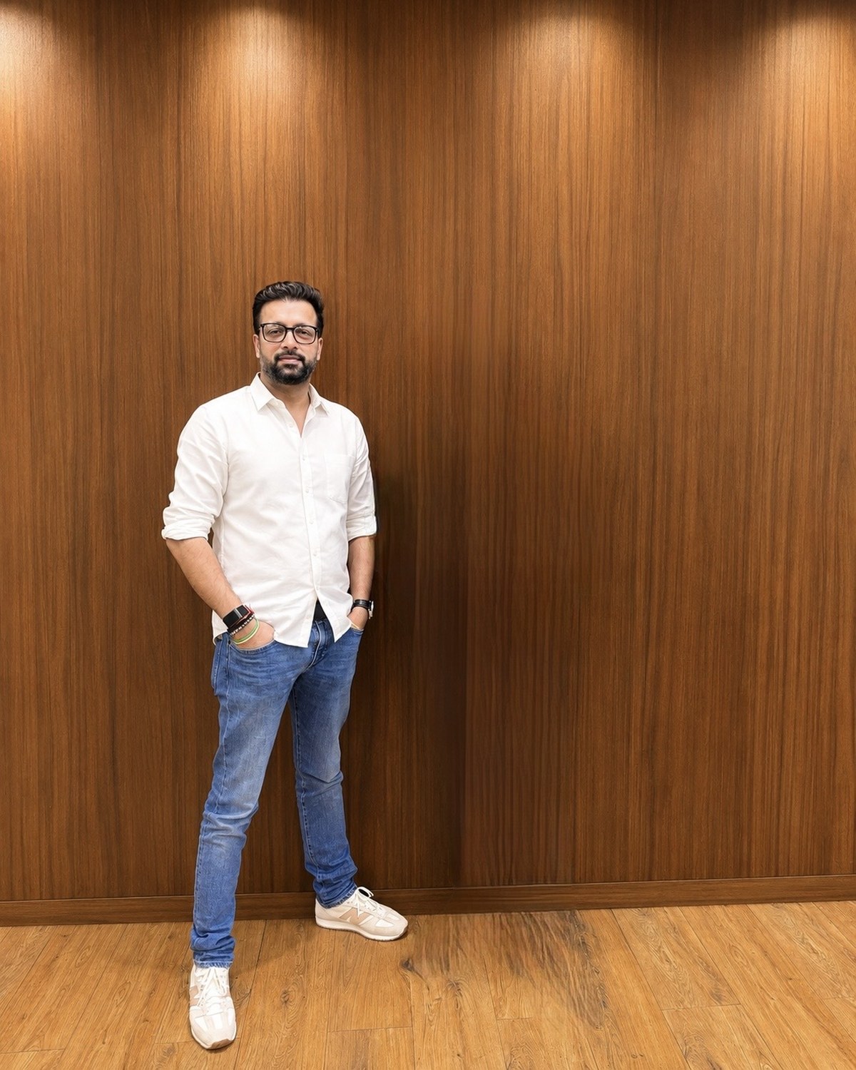 Sahil Jindal in a white shirt standing against a walnut panelled wall in Gurugram