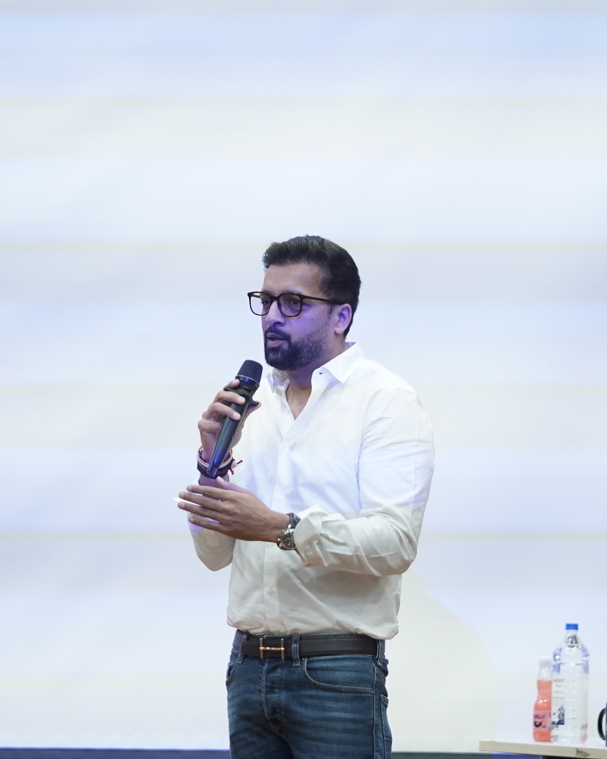 Sahil Jindal speaking with a microphone during a founders session on stage
