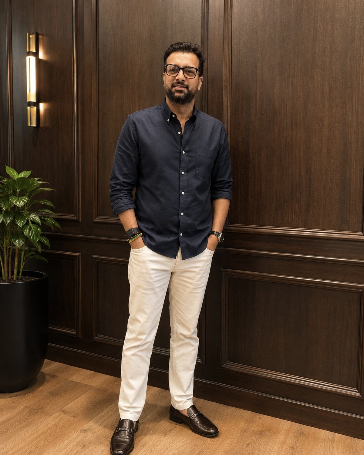 Sahil Jindal in a navy shirt standing against a dark panelled wall at his Gurugram office